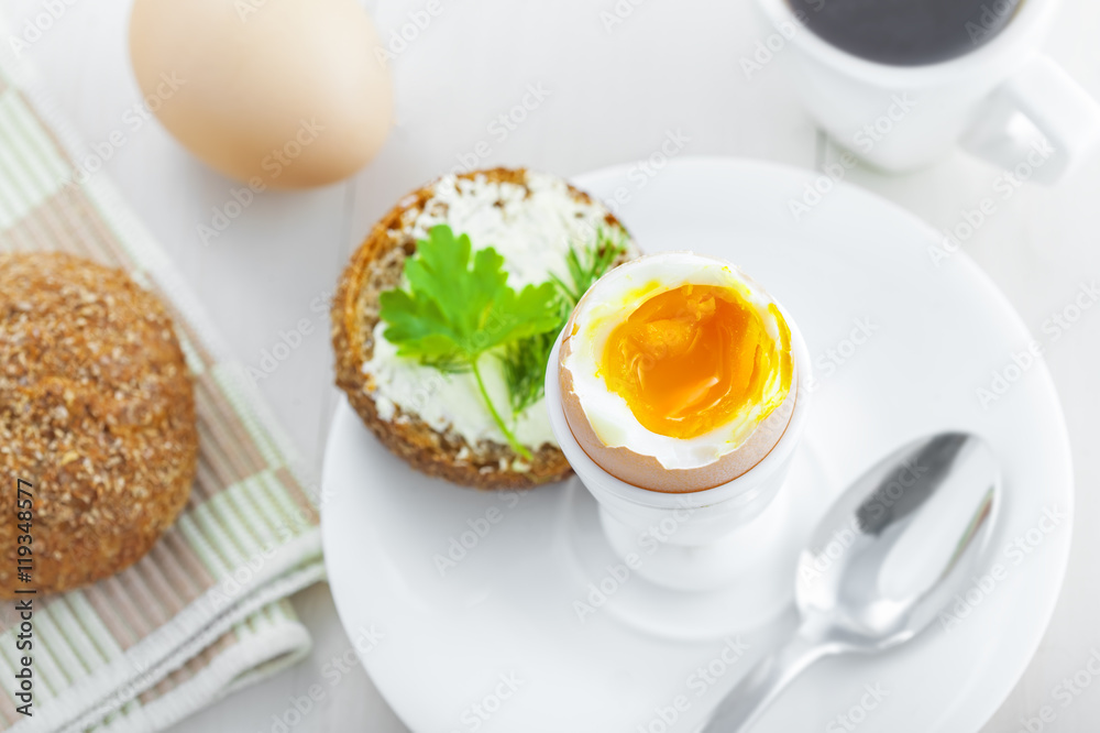 Perfect soft boiled egg, bread and butter, cup of coffee for delicious healthy breakfast on a table. Traditional homemade food. Top view.