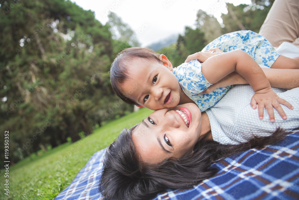 mom and daughter in happines laying on a grass mom and daughter in happines laying on a grass