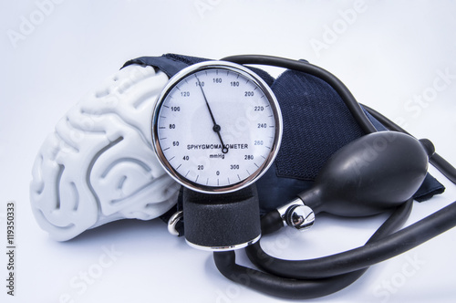 The figure of the human brain enveloped sphygmomanometer cuff with bulb (pear) and dial showing high blood pressure. Concept high brain or increased (raised) intracranial pressure (hypertension) photo