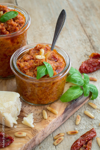 Pesto Rosso mit getrockneten Tomaten, Parmesan Pinienkernen und Basilikum auf einem alten Holzuntergrund