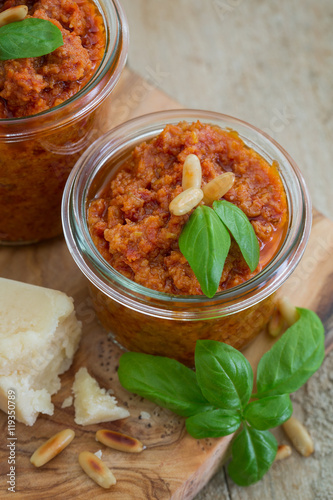 Obraz na płótnie Pesto Rosso mit getrockneten Tomaten, Parmesan Pinienkernen und Basilikum auf einem alten Holzuntergrund w salonie
