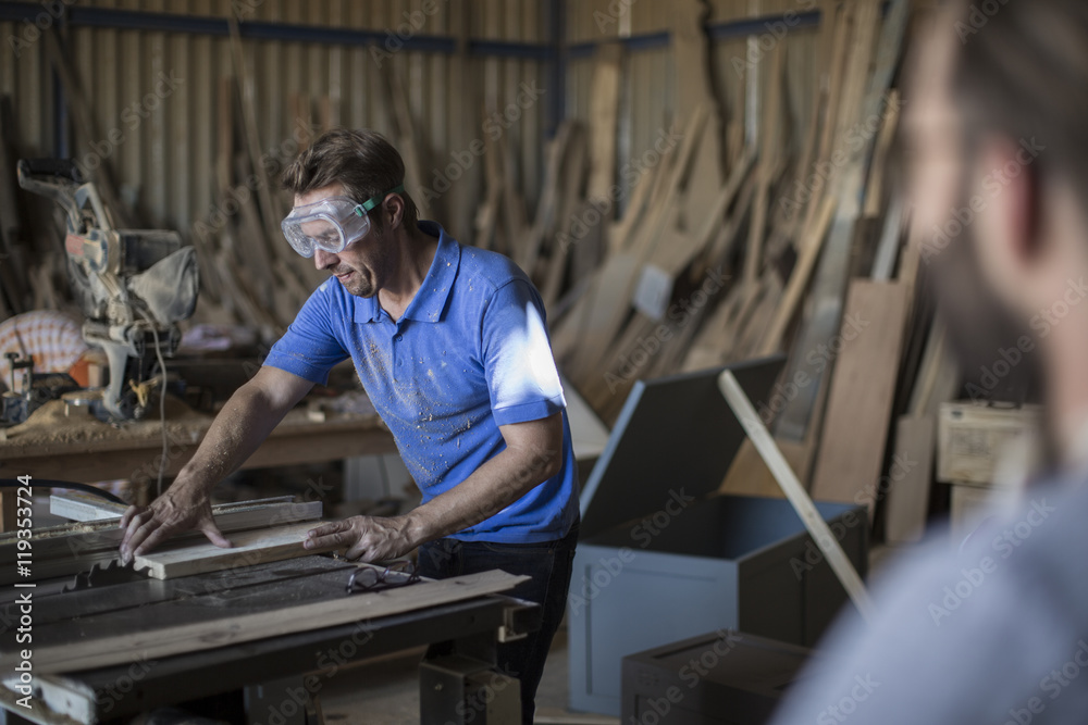 Carpenter working with saw in workshop Carpenter working with saw in workshop