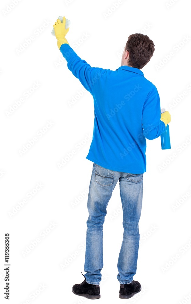 Back view of a cleaner man in gloves with sponge and detergent. girl watching. Curly boy in a warm blue sweater washes a window Back view of a cleaner man in gloves with sponge and detergent. girl watching. Curly boy in a warm blue sweater washes a window