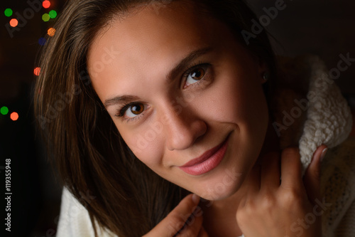 Portrait of beautiful young smiling girl on the background of the winter night and Christmas lights