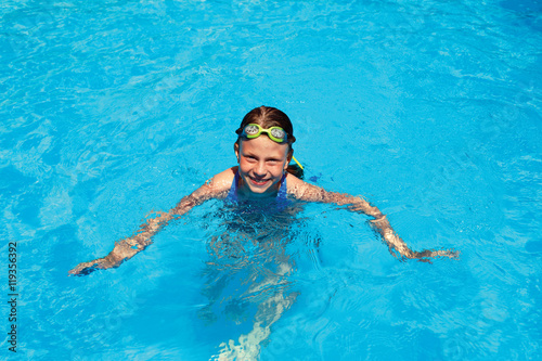 little girl swims in swimming pool