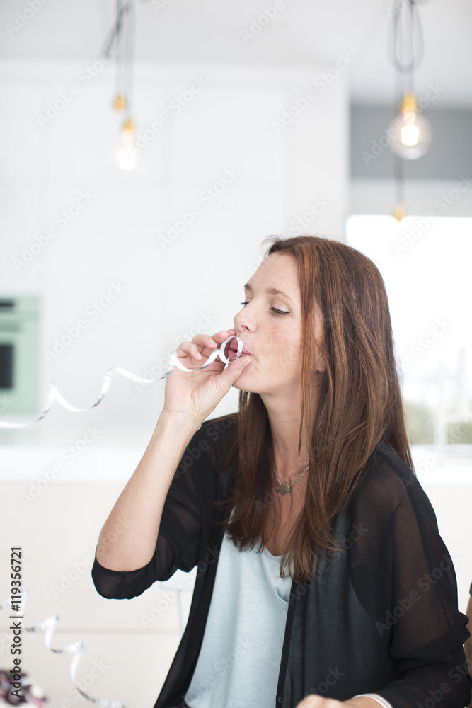 Woman blowing streamer at her sons first birthday Woman blowing streamer at her sons first birthday