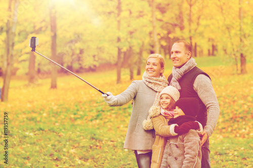 happy family with smartphone and monopod in park