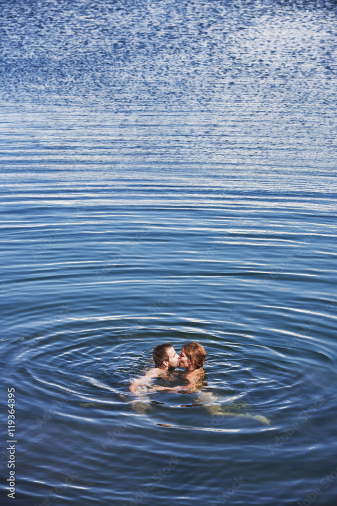 Mid adult couple kissing in sea, Bohuslan, Sweden Mid adult couple kissing in sea, Bohuslan, Sweden