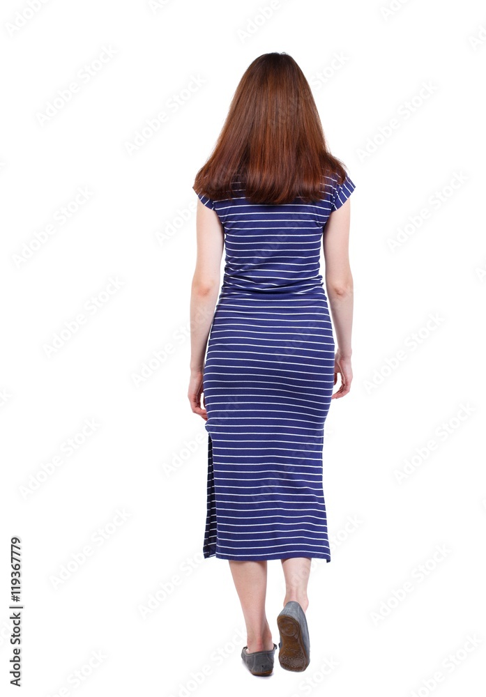 back view of walking woman. brunette in a blue striped dress went off. back view of walking woman. brunette in a blue striped dress went off.