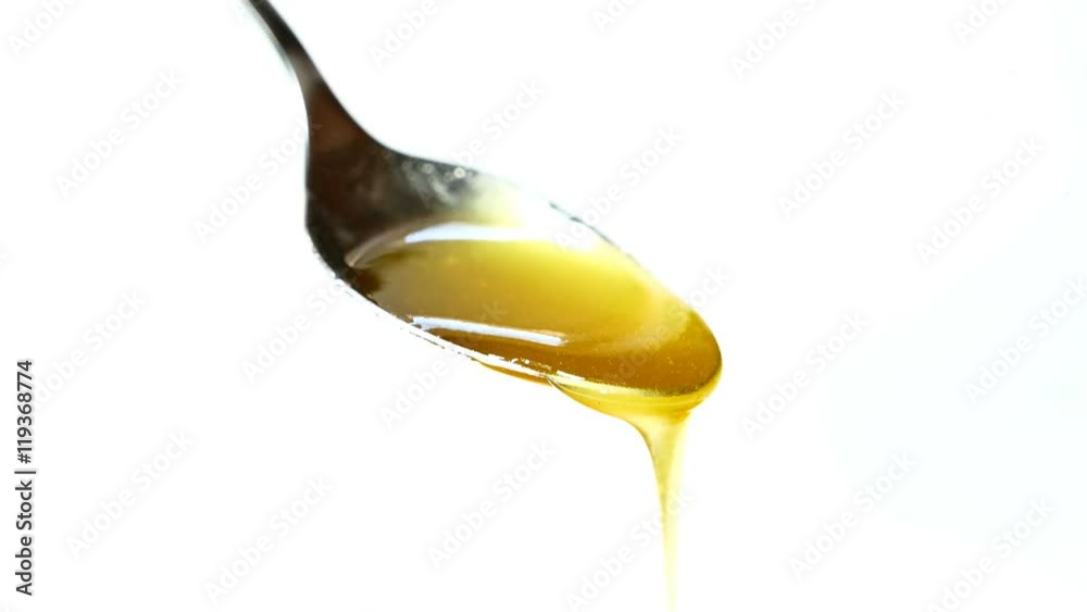 honey dripping on a spoon close-up honey dripping on a spoon close-up
