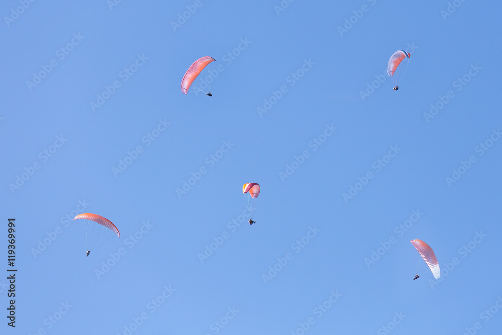 A lot of skydivers in clear blue sky.