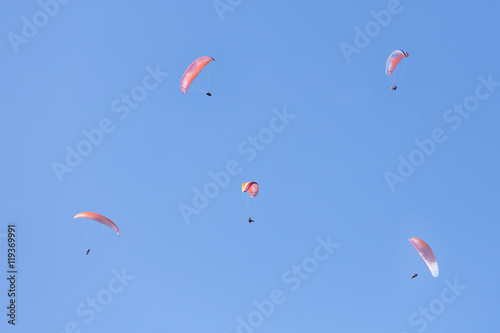 A lot of skydivers in clear blue sky.