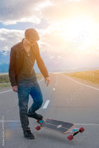 Man is going to skateboarding on the road. Flying longboard.