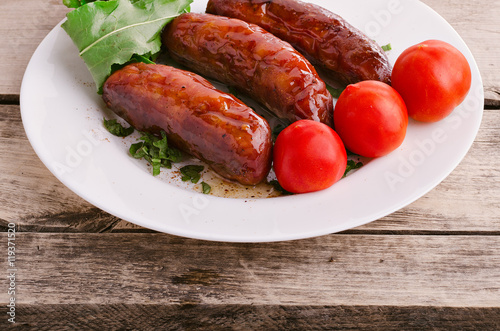 Sausage. Delicious sausages in a plate with ingredients. Salad.