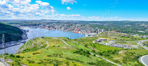 Panoramic views with bight blue summer day sky with puffy clouds over the harbour and city of St. John's Newfoundland, Canada.