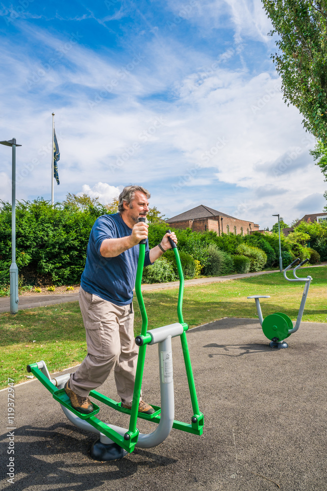 Fototapeta premium Middle aged man exercising in the outdoor gym