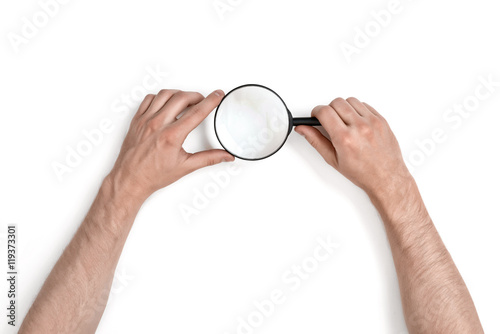 Hands of man holding the magnifying glass isolated on white background