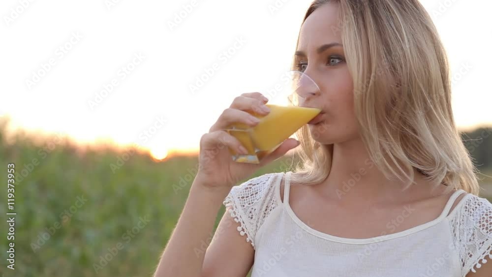 Healthy woman drinking orange juice and smiling