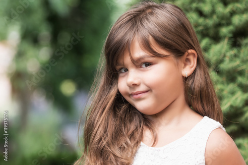 Portrait of smiling attractive little girl outdoors. 