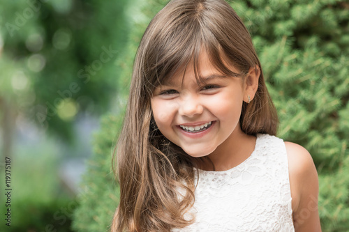 Portrait of laughing attractive little girl outdoors. 