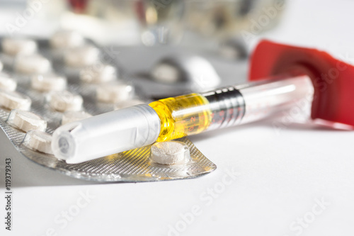 Pills, syrenge depicting pharmacy industry or hospital treatment photo
