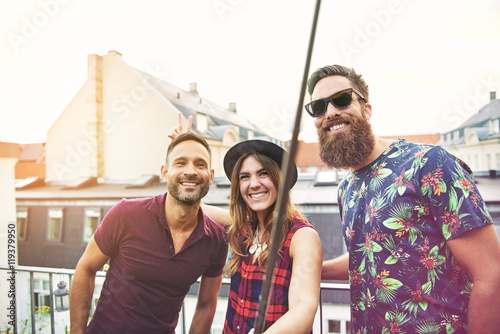 Woman and two male friends stand on patio