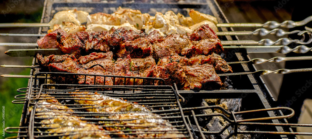 closeup of some meat skewers being grilled in a barbecue.
