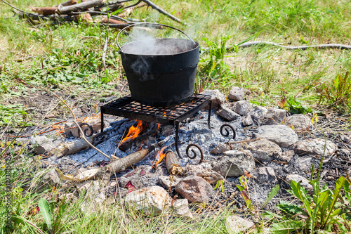 Cooking on a camp fire outdoors in summer sunny day