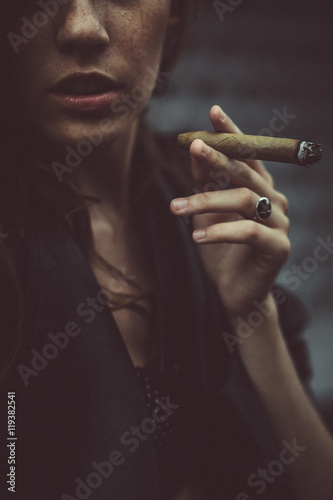 Closeup of woman's lips and cigar held before them photo