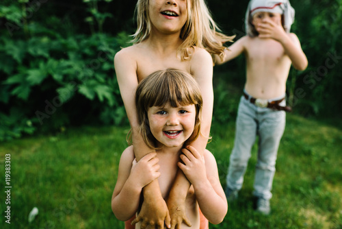 Three children playing outside in garden, close up