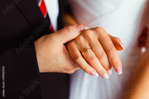 Man holds tender bride's hand with french nails