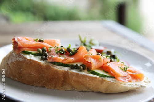 smoked salmon on toasted bread with cream fresh, lemon and salad