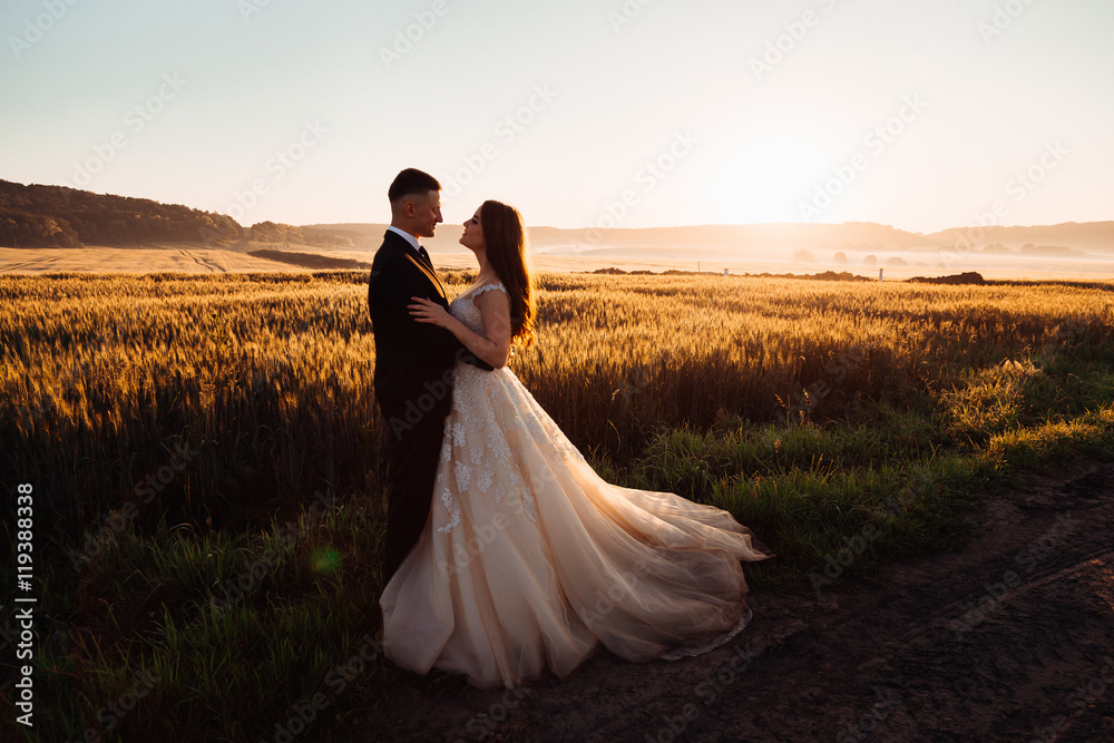 Colorful nature surrounds comely hugging wedding couple