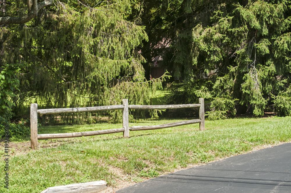 Decorative wooden fence along park asphalt alley Decorative wooden fence along park asphalt alley