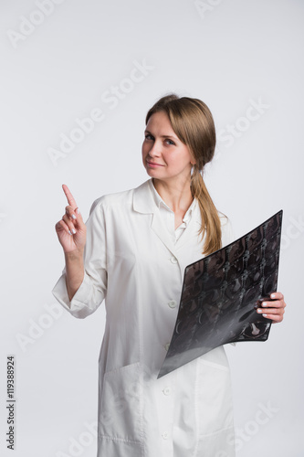 Doctor holding a X-ray and pointing to blank copy space, white background photo