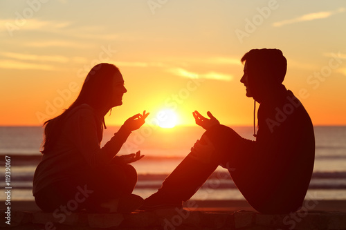 Friends or couple of teens talking at sunset
