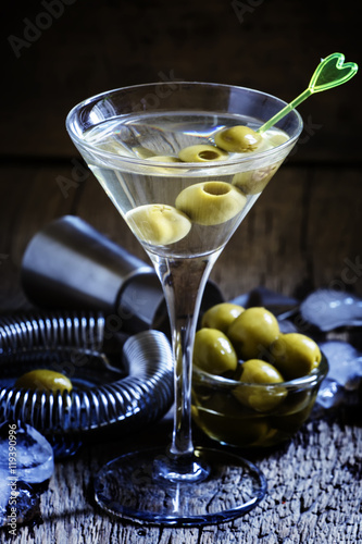 Dry martini, vermouth with green olives, black background, selec photo