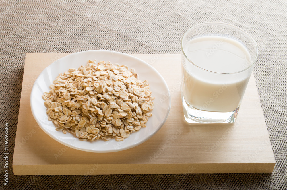 Glass of milk and a plate of cereal in backligh Glass of milk and a plate of cereal in backligh