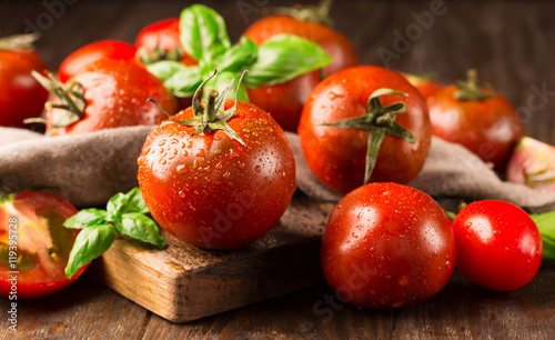 Fresh ripe organic tomatoes on old rustic background, selective focus
