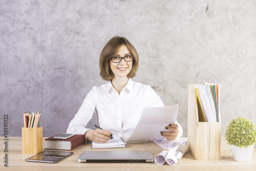 Happy businesswoman doing paperwork