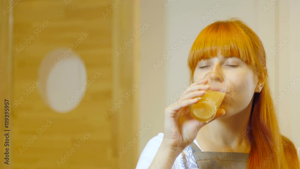 Woman drinking orange juice smiling showing oranges. Woman drinking orange juice smiling showing oranges.