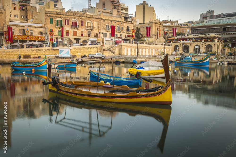 St.Julian's, Malta - Traditional colorful Luzzu fishing boats at Spinola bay at sunrise - obrazy, fototapety, plakaty 