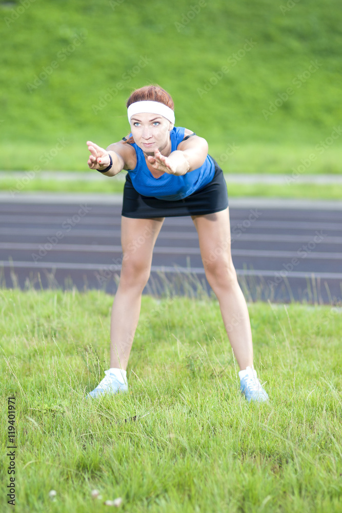 Young Red Haired Ginger Caucasian Female in Athletic Sportgear Having Body Bending Exercises