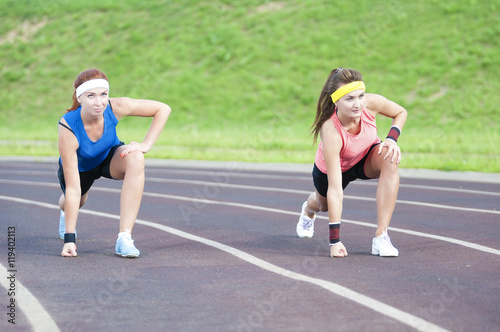 Two Caucasian Sportswomen in Professional Sportsgear Standing Prior to Running