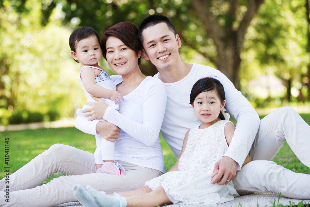 Young happy Asian family enjoying a sunny day at the park.