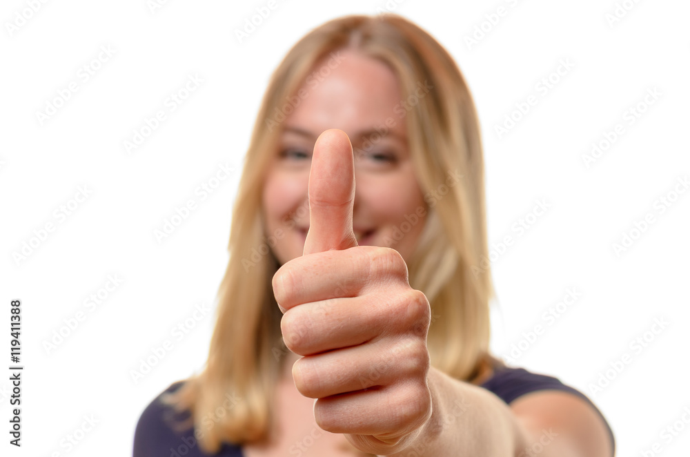 Smiling woman giving a thumbs up of approval Smiling woman giving a thumbs up of approval