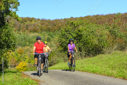 Fototapeta Naklejka Na Ścianę i Meble -  Drei gutgelaunte Seniorinnen machen eine Radtour im Herbst