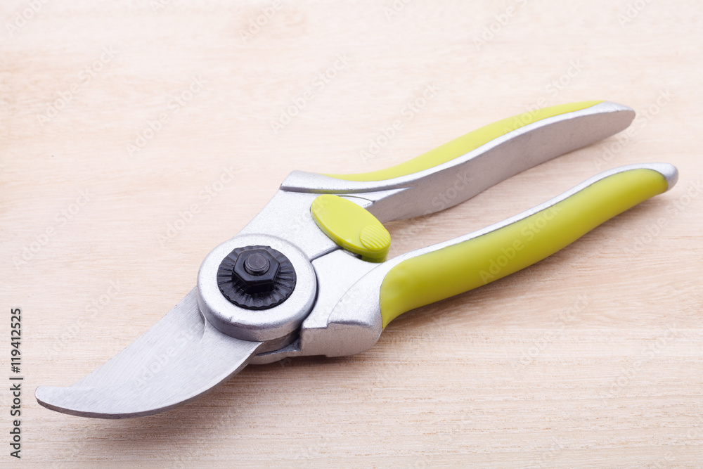 green garden secateurs on wood background green garden secateurs on wood background