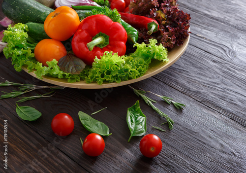 Dish of fresh vegetables on wooden background with copy space