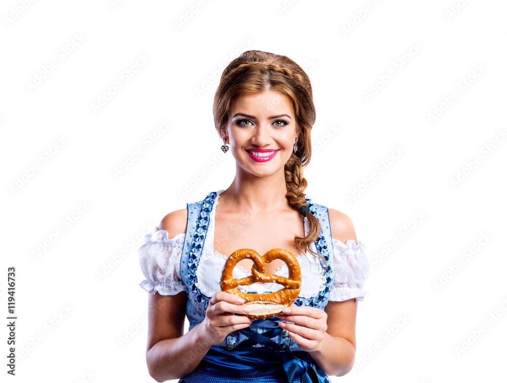 Beautiful woman in traditional bavarian dress holding a pretzel